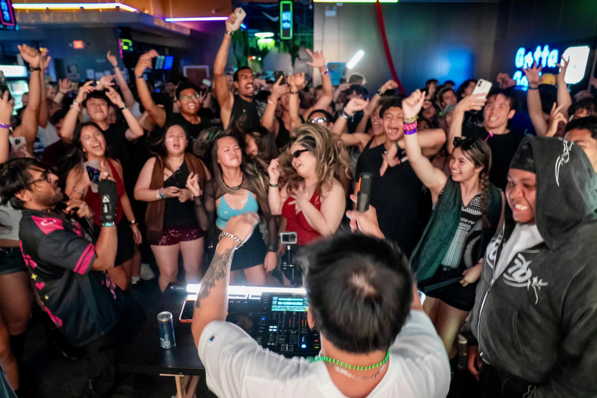 Crowd reaching toward the DJ booth